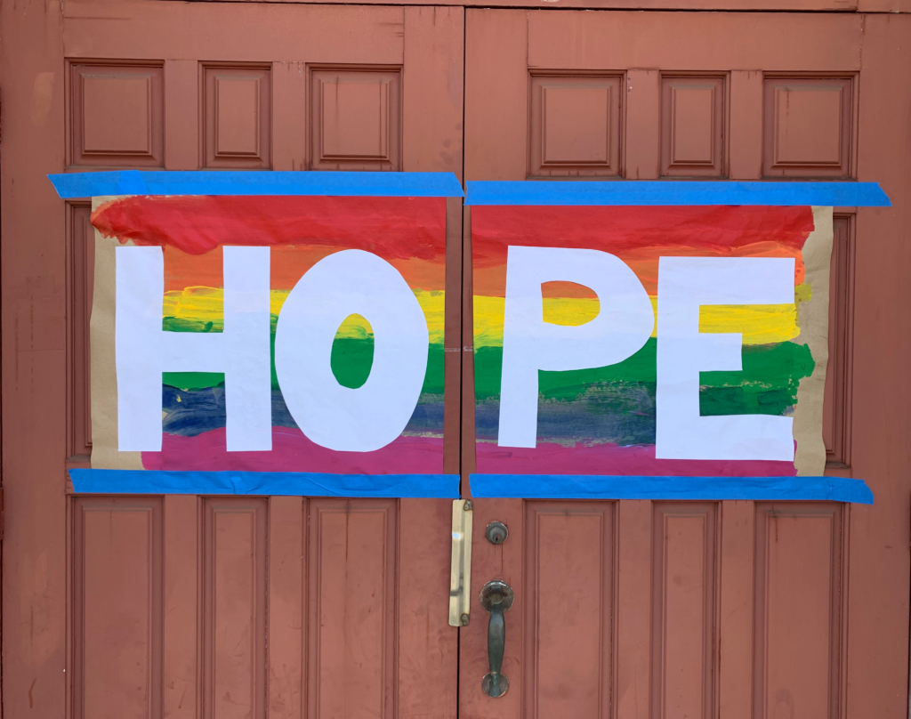 Rainbow sign on church doors reading "Hope"